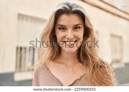 Young blonde woman smiling confident standing at street