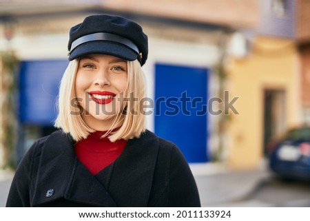 Young blonde woman smiling happy standing at the city.