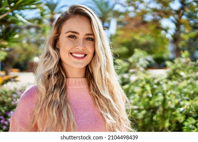 Young blonde woman smiling at the park