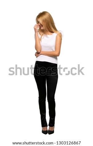 Young blonde woman smiling a lot while putting hands on chest over isolated white background