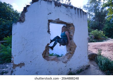 Young Blonde Woman In Sportswear, Doing Calisthenics Exercises In A Window Of A Dilapidated Building. Concept, Calisthenics, Fitness, Exercise, Curvy Girl.