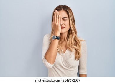 Young Blonde Woman Standing Over Isolated Background Yawning Tired Covering Half Face, Eye And Mouth With Hand. Face Hurts In Pain. 