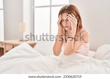 Young blonde woman stressed sitting on bed at bedroom