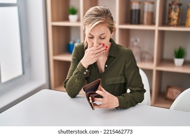 Young Blonde Woman Surprised Looking Empty Wallet At Home