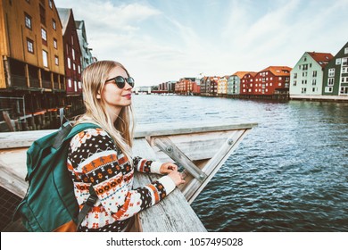 Young blonde woman traveling in Trondheim city Norway vacations weekend Lifestyle outdoor girl tourist with backpack sightseeing scandinavian architecture alone