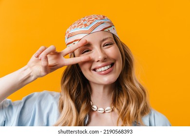 Young Blonde Woman Wearing Bandanna Smiling And Gesturing Peace Sign Isolated Over Yellow Background