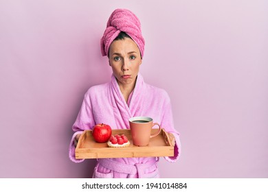 Young blonde woman wearing bathrobe holding tray with breakfast depressed and worry for distress, crying angry and afraid. sad expression.  - Powered by Shutterstock