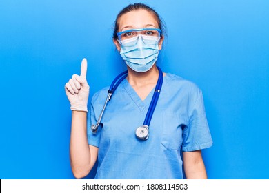 Young Blonde Woman Wearing Doctor Uniform And Coronavirus Protection Holding Help Reminder Smiling With An Idea Or Question Pointing Finger Up With Happy Face, Number One 