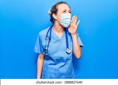 Young blonde woman wearing doctor uniform and medical mask shouting and screaming loud to side with hand on mouth. communication concept. 