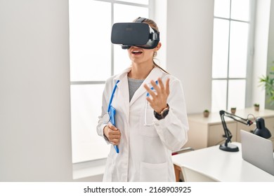 Young Blonde Woman Wearing Doctor Uniform Using Touchpad And Vr Goggles At Clinic