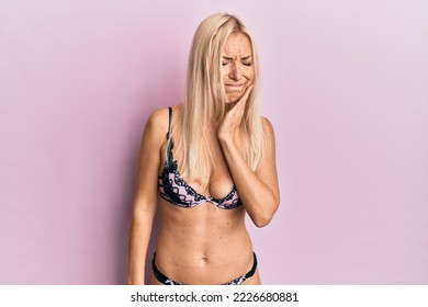 Young Blonde Woman Wearing Lingerie Touching Mouth With Hand With Painful Expression Because Of Toothache Or Dental Illness On Teeth. Dentist 