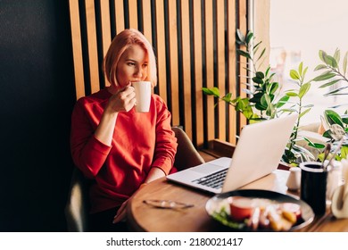 Young Blonde Woman Wearing Red Casual Sweater In Cafe Working On The Laptop Computer And Drinking Coffe Lifestyle