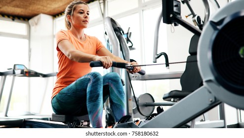 Young Blonde Woman Working On Rowing Machine