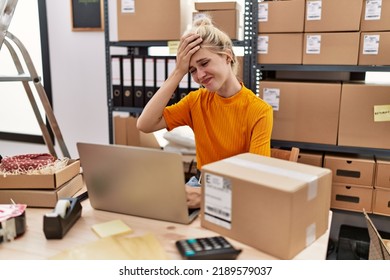 Young Blonde Woman Working At Small Business Ecommerce Using Laptop Stressed And Frustrated With Hand On Head, Surprised And Angry Face 