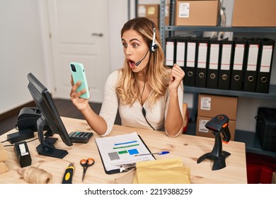 Young Blonde Woman Working At Small Business Ecommerce Using Headset Scared And Amazed With Open Mouth For Surprise, Disbelief Face 