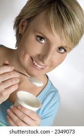 Young Blondie Woman Eating Yogurt Close Up