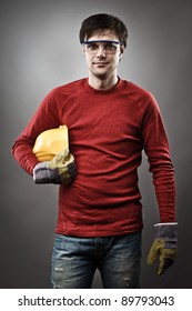 Young Blue Collar Worker With Yellow Protective Helmet And Gloves