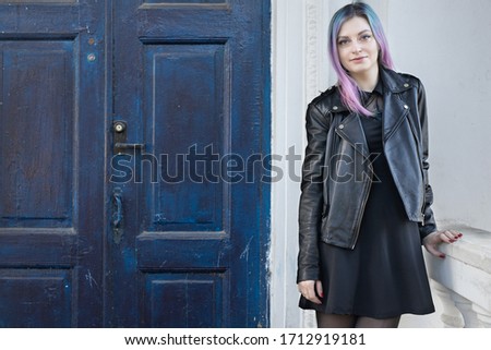 Young blue violet haired girl near the old door