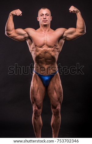 young bodybuider posing in studio