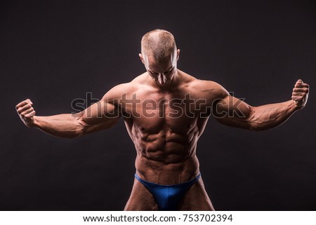 young bodybuider posing in studio