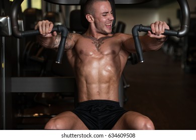 Young Bodybuilder Doing Heavy Weight Exercise For Chest On Machine