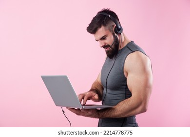 Young Bodybuilder, Online Fitness Coach, Using A Laptop And A Headset To Talk To An Online Client, Studio Image