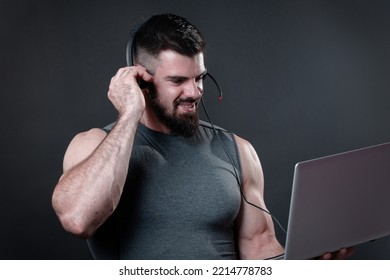 Young Bodybuilder, Online Fitness Coach, Using A Laptop And A Headset To Talk To An Online Client, Studio Image