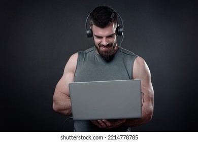 Young Bodybuilder, Online Fitness Coach, Using A Laptop And A Headset To Talk To An Online Client, Studio Image