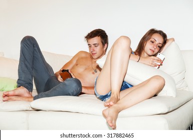 Young Bored Couple On The Couch, Chatting Alone