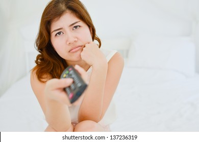 A Young Bored Woman Watching Tv With Remote