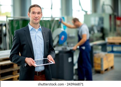 young boss with worker in the background in his factory - Powered by Shutterstock