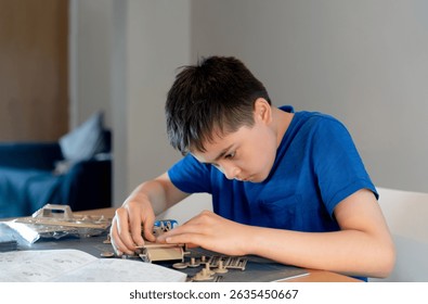 Young boy assembling plastic model,Kid learning  process of building toy car on table with various materials, parts devices,Concept of lifestyle learn through play activity for kid education,Hobby 