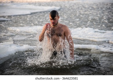 A young boy is bathed in the icy water. The Christian holiday of Epiphany.