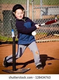 Young boy batting at T-ball practice