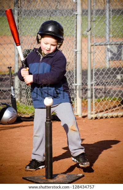Young boy batting at
T-ball practice