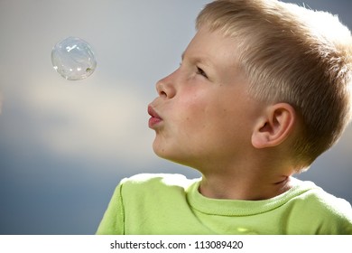 Young boy blowing bubbles