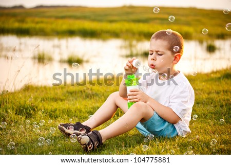 Adorable little girl playing with a ball sitting on a park bench