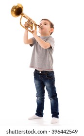 young boy blowing into a trumpet against white background