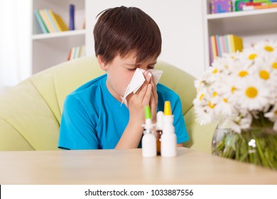 Young Boy Blowing Nose With Nazal Sprays And Other Medication In Foreground - Allergy Cocnept