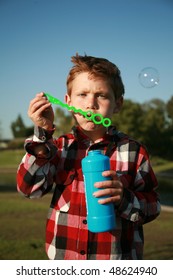 a young boy blows bubbles