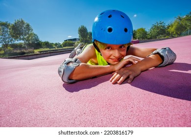 Young Boy In Blue Helmet And Rollerblades In The Skatepark Rest On The Color Surface Smiling