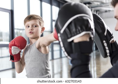 young boy boxer practicing punches with coach 