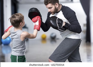 young boy boxer practicing punches with coach  - Powered by Shutterstock