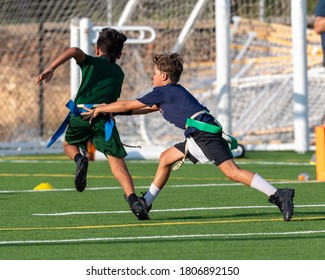 Young Boy Catching, Running And Throwing The Ball In A Football Game