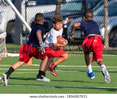 Young boy catching, running and throwing the ball in a football game