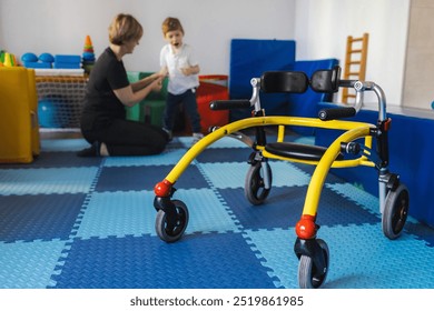 Young boy with cerebral palsy participates in physical therapy assisted by a therapist in a vibrant rehabilitation environment using open frame walker - Powered by Shutterstock