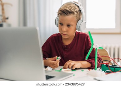 Young boy is connecting peaces o create a windmill model for a school project. - Powered by Shutterstock