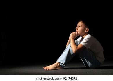 young boy in a dark room posing