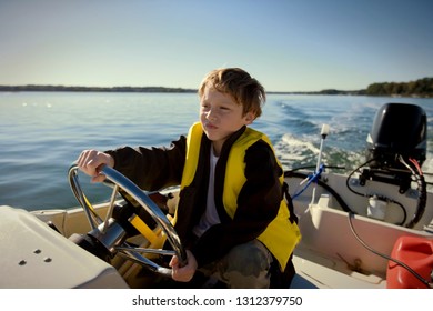 Young boy diving a boat in the ocean.