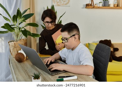 A young boy with Down syndrome sits at a desk with a friend, using a laptop. - Powered by Shutterstock